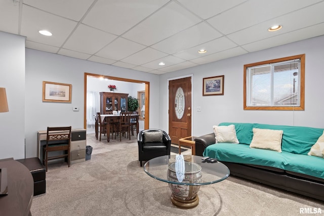 carpeted living room with a drop ceiling