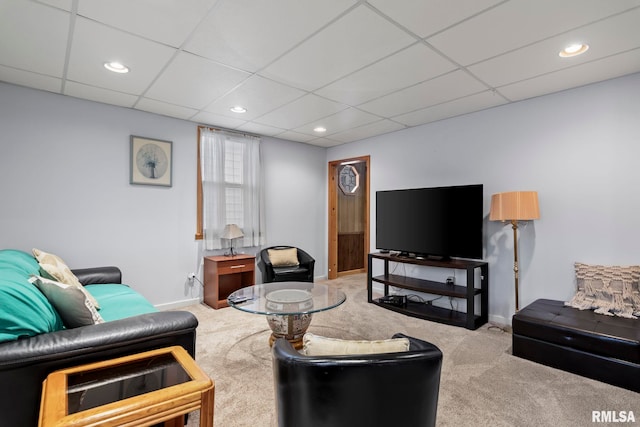 living room with a drop ceiling and light colored carpet