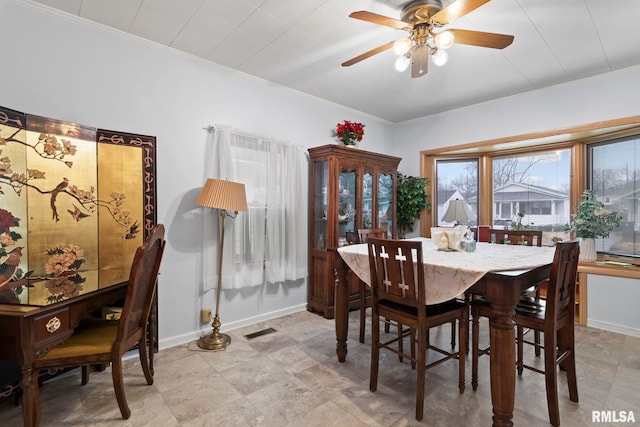 dining area with ornamental molding and ceiling fan