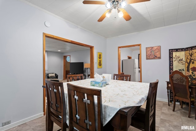 dining space with ornamental molding and ceiling fan