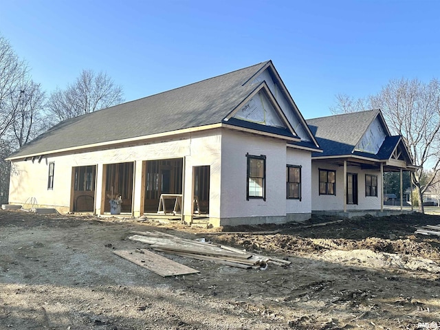 rear view of property with covered porch