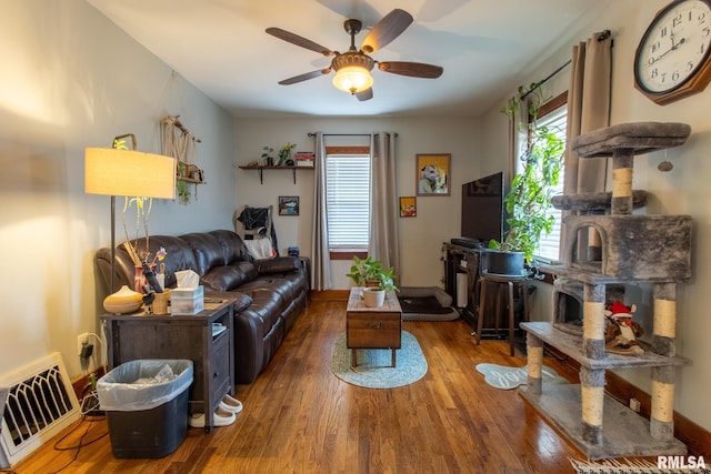 living room with ceiling fan and dark hardwood / wood-style flooring