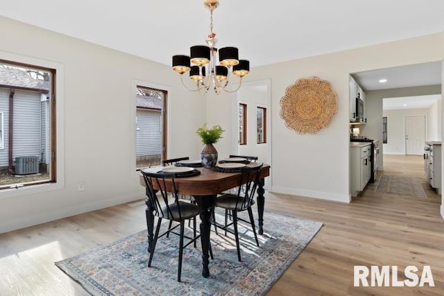 dining room with a wealth of natural light, a chandelier, and light wood-type flooring