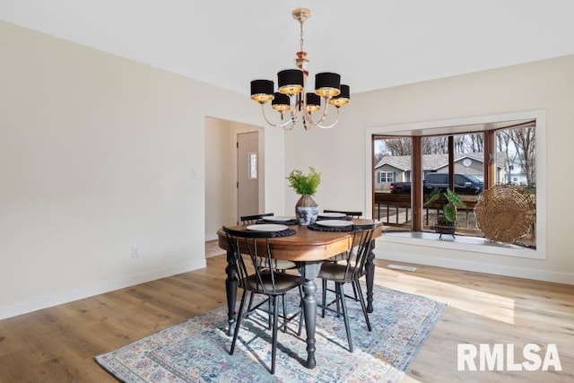 dining room with hardwood / wood-style floors and a chandelier