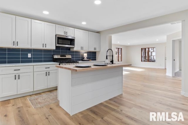 kitchen with white cabinetry, a kitchen island with sink, and stainless steel appliances