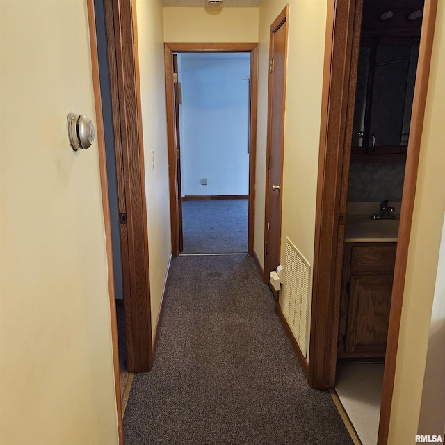 corridor featuring dark colored carpet