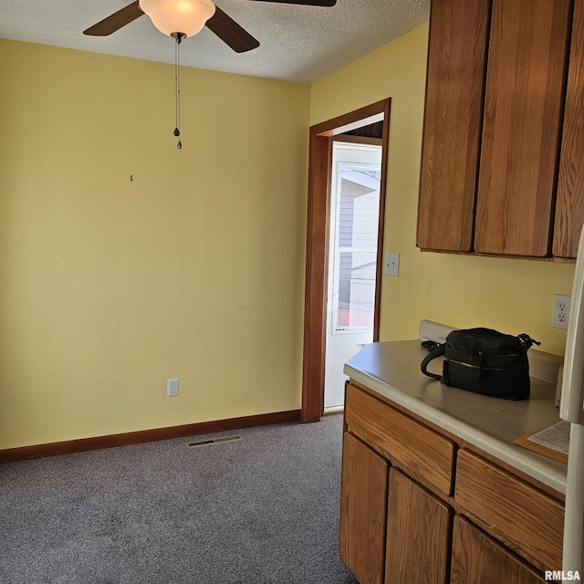 interior space with ceiling fan, dark carpet, and a textured ceiling