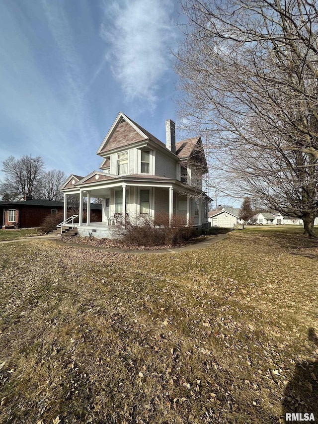 back of property with a lawn and a porch