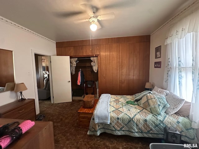 carpeted bedroom featuring a closet, ceiling fan, and wood walls