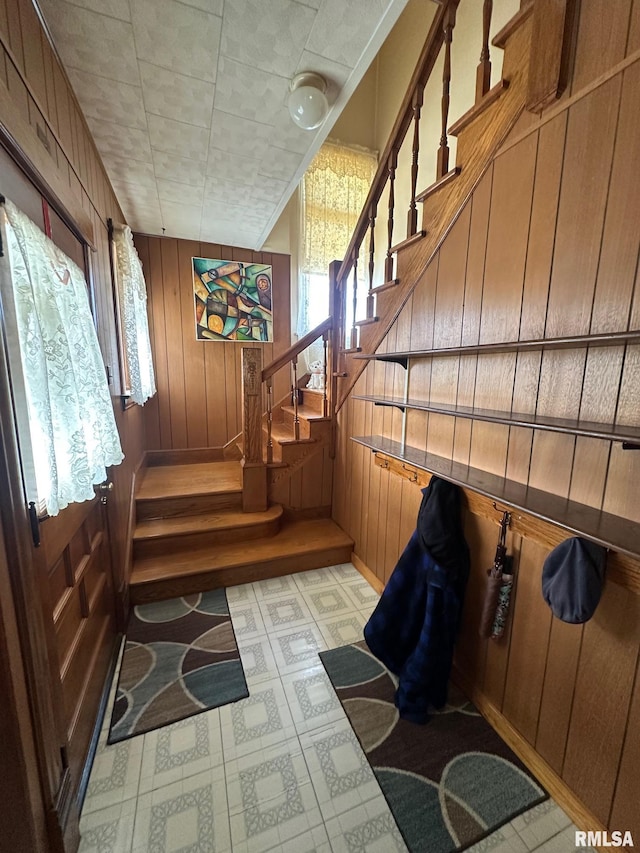 stairs featuring wood walls