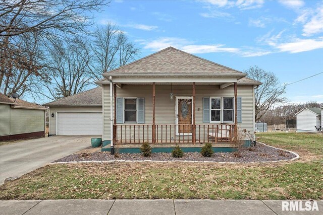 bungalow-style home with a garage, a front yard, and a porch