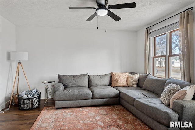 living room featuring ceiling fan, a textured ceiling, and dark hardwood / wood-style flooring