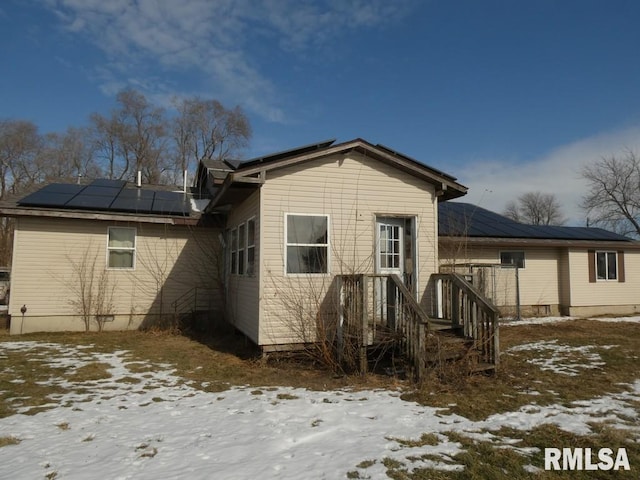 snow covered house with solar panels