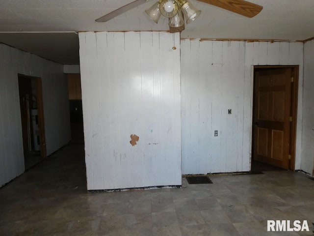 spare room with wooden walls and ceiling fan