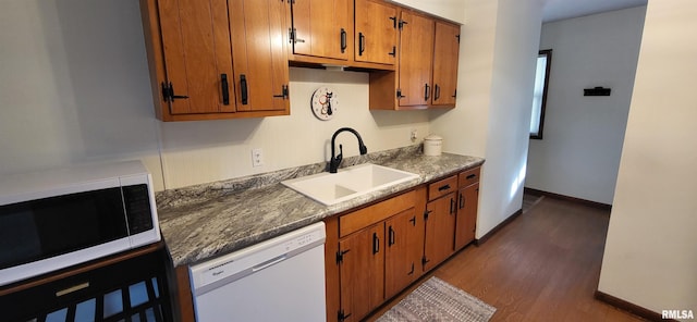 kitchen with dark hardwood / wood-style flooring, sink, and white appliances