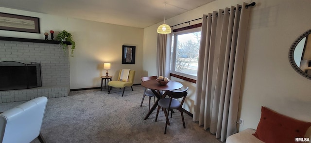 living area with a brick fireplace and carpet flooring