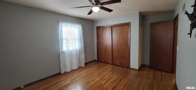 unfurnished bedroom with hardwood / wood-style flooring, a closet, and ceiling fan