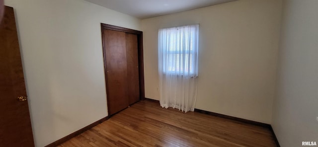 unfurnished bedroom with wood-type flooring and a closet