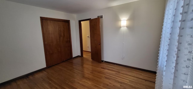 unfurnished bedroom with hardwood / wood-style floors and a closet