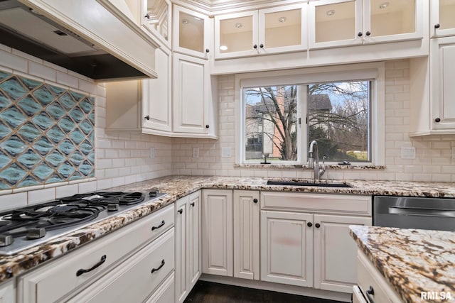 kitchen with appliances with stainless steel finishes, sink, custom exhaust hood, and white cabinets