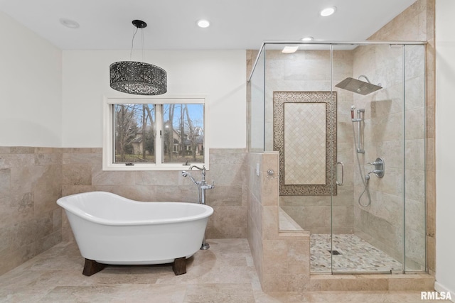 bathroom with tile walls and independent shower and bath