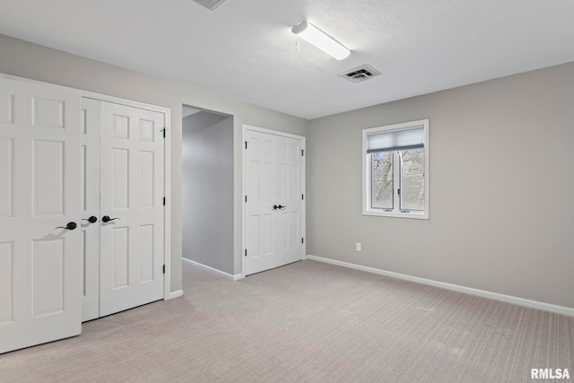 unfurnished bedroom featuring light colored carpet and a textured ceiling