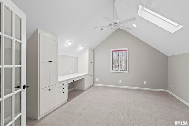 bonus room featuring ceiling fan, light colored carpet, and lofted ceiling with skylight