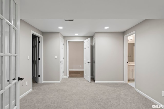 hallway with french doors and light colored carpet