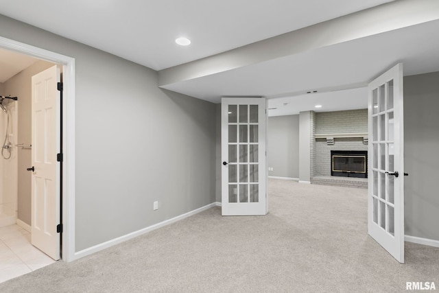 spare room with light carpet, a fireplace, and french doors