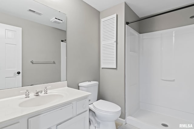 bathroom with vanity, a shower, and toilet