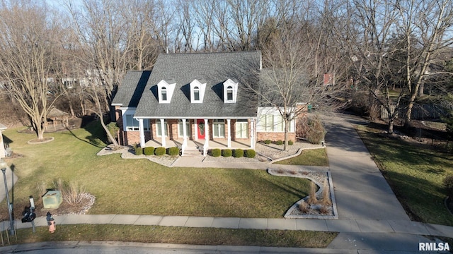 cape cod house featuring covered porch and a front lawn