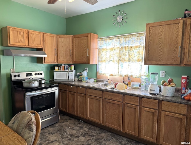 kitchen featuring white microwave, exhaust hood, stainless steel electric range, brown cabinets, and dark countertops