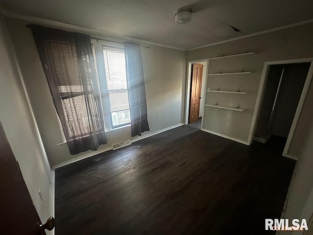 empty room with ornamental molding and dark wood-type flooring