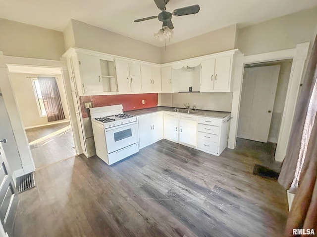 kitchen with white range with gas stovetop, white cabinets, dark wood-type flooring, open shelves, and a sink