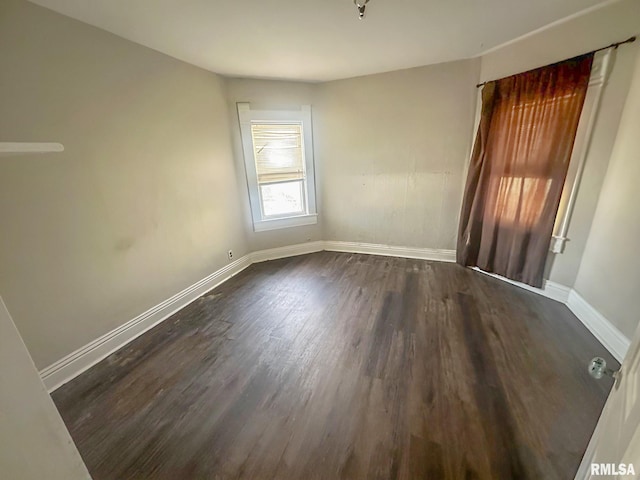 unfurnished room featuring dark wood-type flooring and baseboards