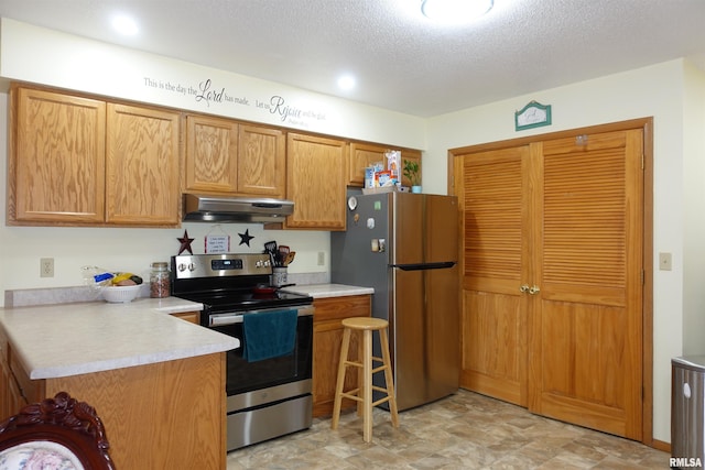 kitchen with stainless steel appliances and a textured ceiling