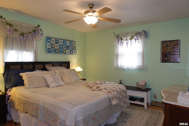 bedroom with ceiling fan and multiple windows