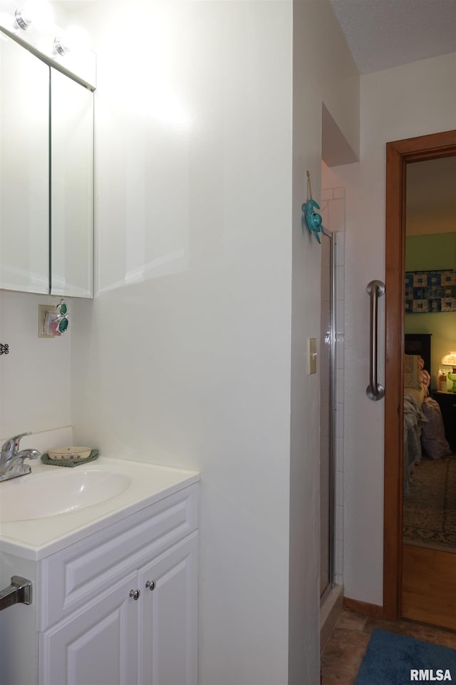 bathroom featuring vanity and a shower with shower door