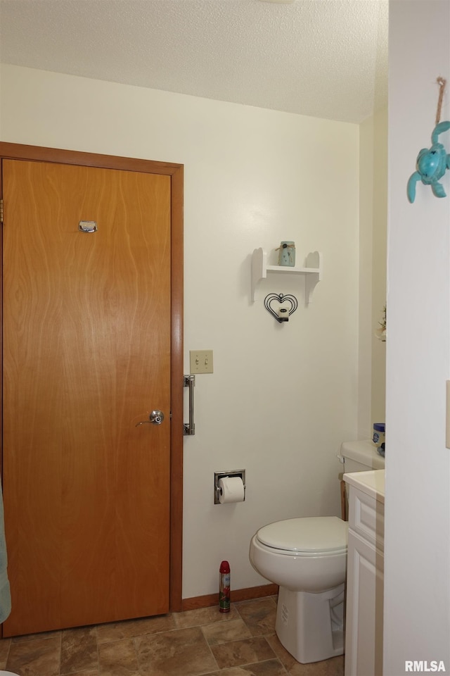 bathroom featuring vanity, toilet, and a textured ceiling