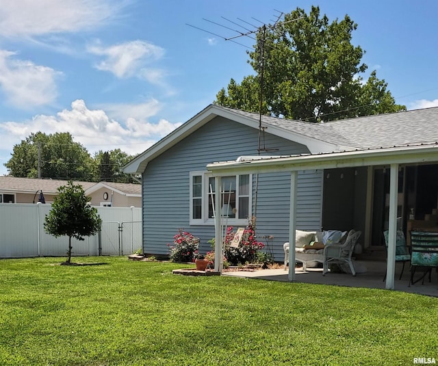 rear view of property with a yard and a patio