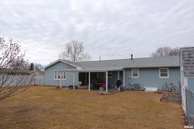 rear view of property featuring central AC unit, a lawn, and a patio