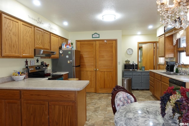 kitchen featuring sink, stainless steel appliances, kitchen peninsula, and a textured ceiling