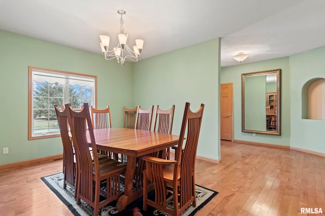 dining space with an inviting chandelier and light hardwood / wood-style flooring