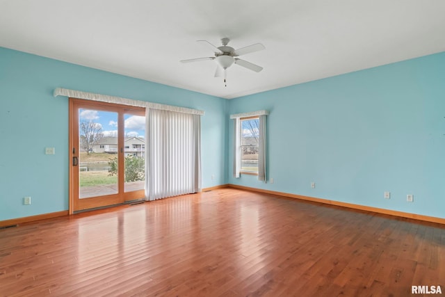 unfurnished room featuring hardwood / wood-style floors, a wealth of natural light, and ceiling fan