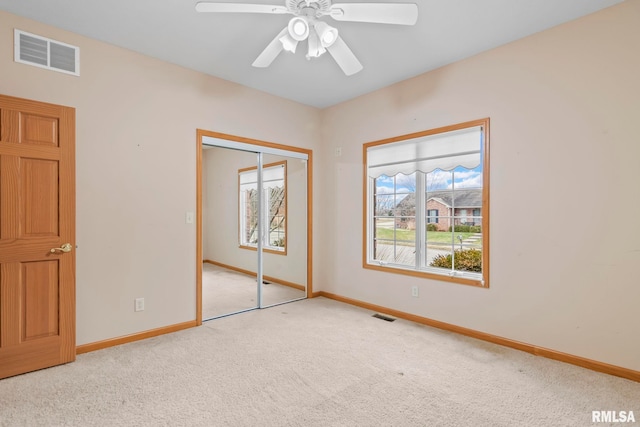 unfurnished bedroom featuring light carpet, ceiling fan, and a closet