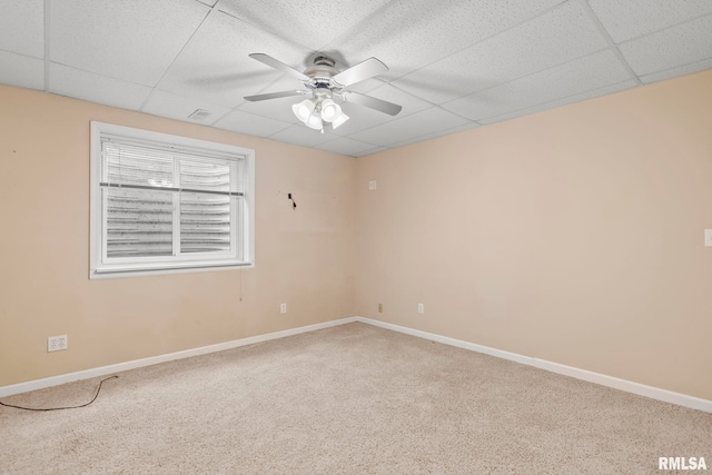 empty room featuring ceiling fan, a paneled ceiling, and carpet floors