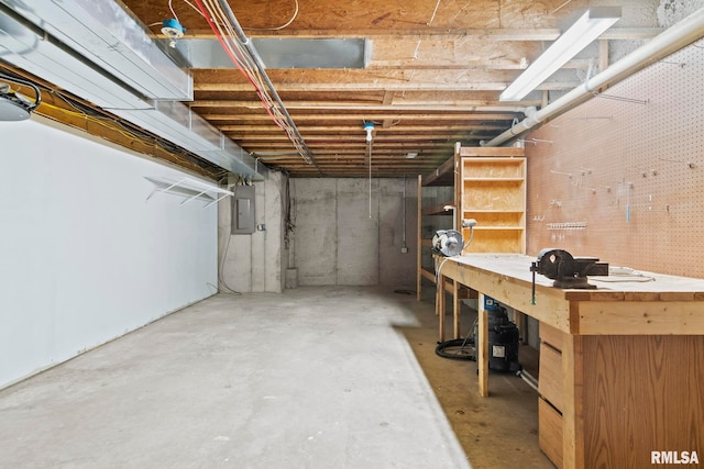 basement featuring electric panel and a workshop area