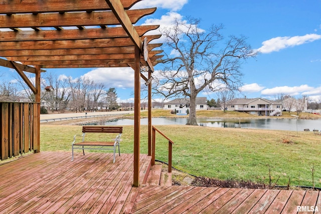 wooden deck featuring a pergola, a lawn, and a water view