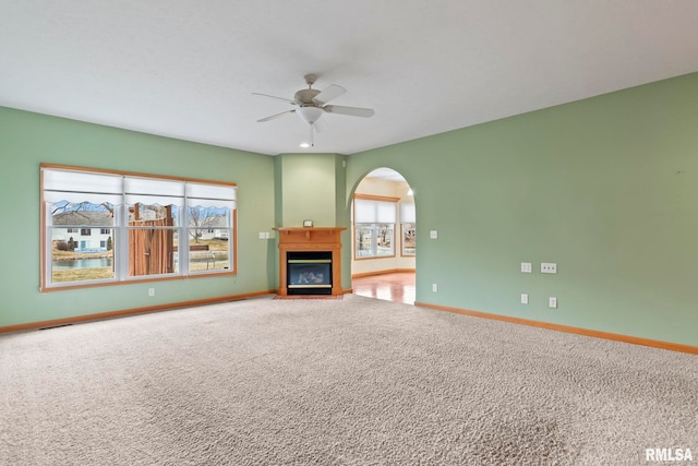 unfurnished living room with ceiling fan and carpet flooring