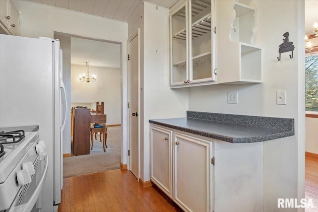 kitchen featuring hanging light fixtures, a notable chandelier, white gas range oven, and light hardwood / wood-style flooring